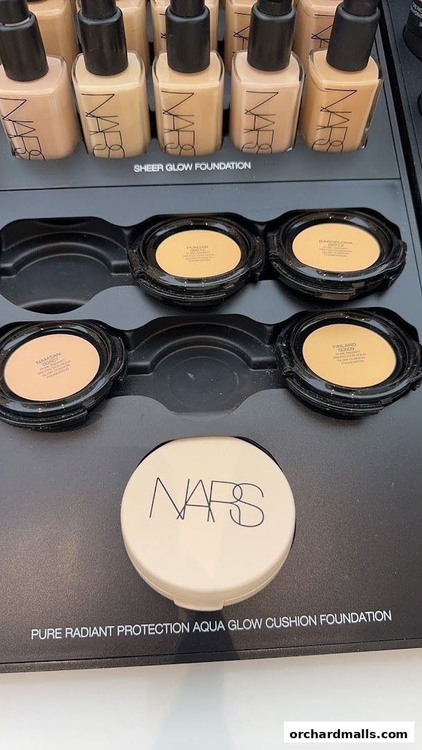 NARS foundation products displayed, including Sheer Glow and Aqua Glow Cushion foundations.
