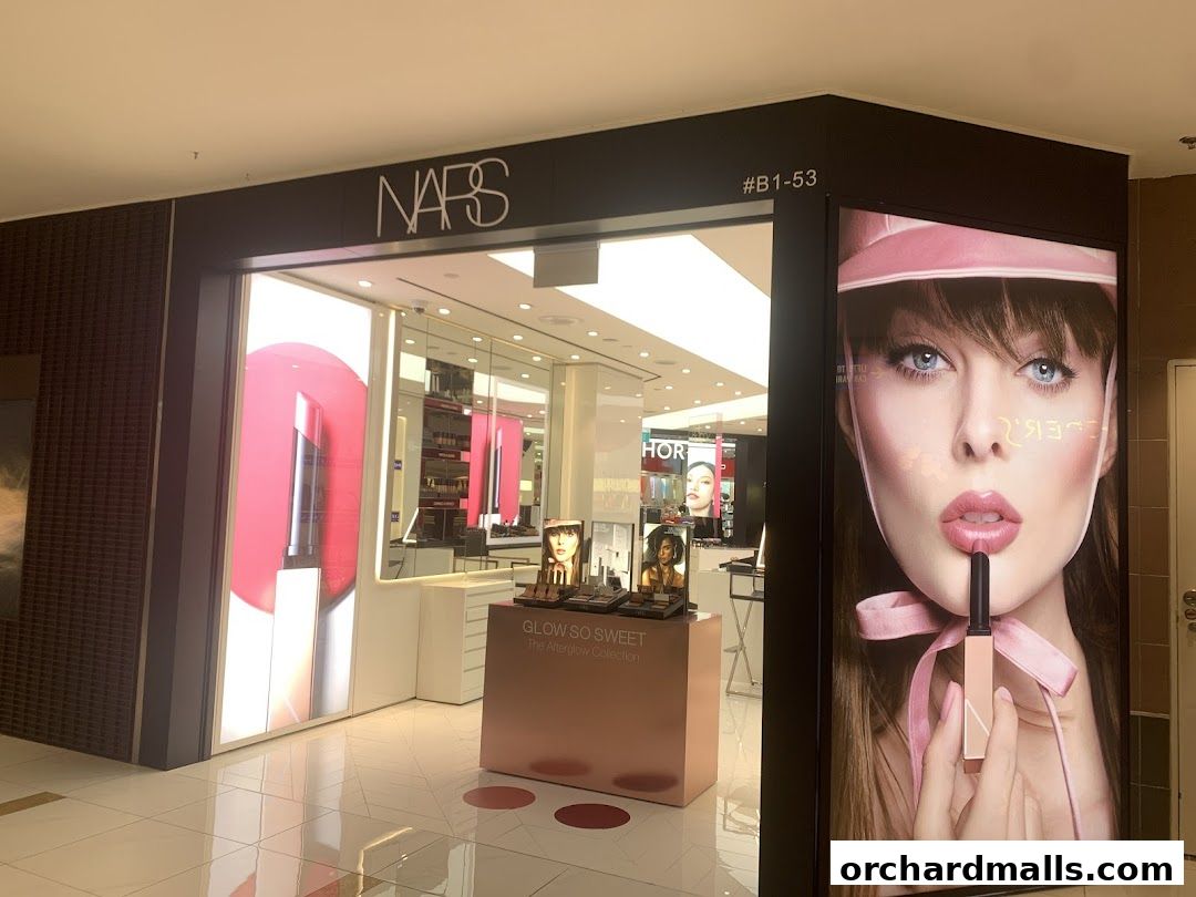 The NARS cosmetics store entrance features a large display of lipstick and a model.