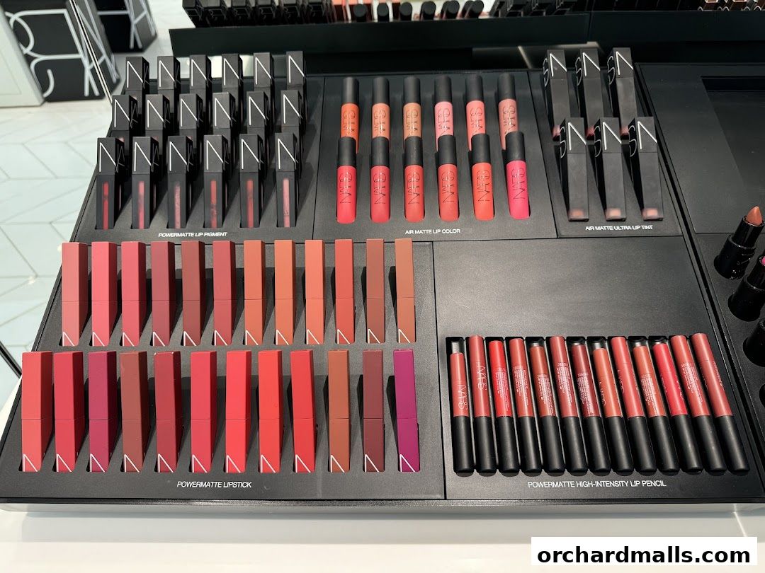 A display of various NARS lip products, including lipsticks, lip tints, and lip pencils in a range of shades.