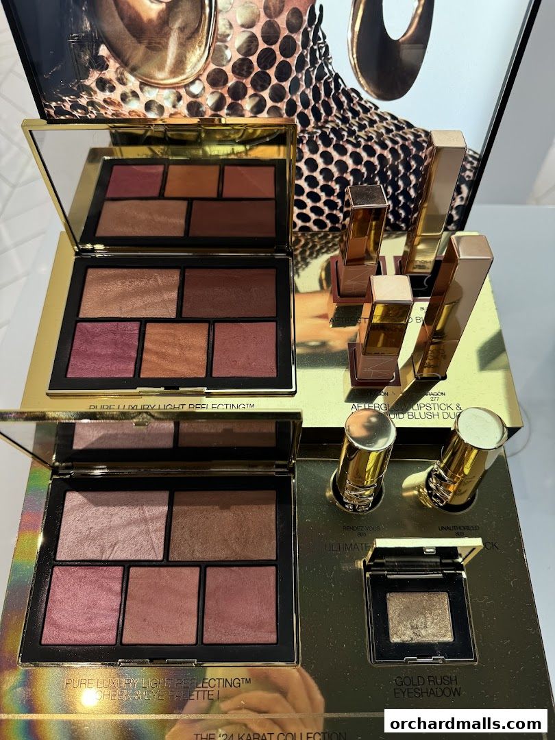 NARS makeup palettes and lipsticks displayed in luxurious gold packaging.