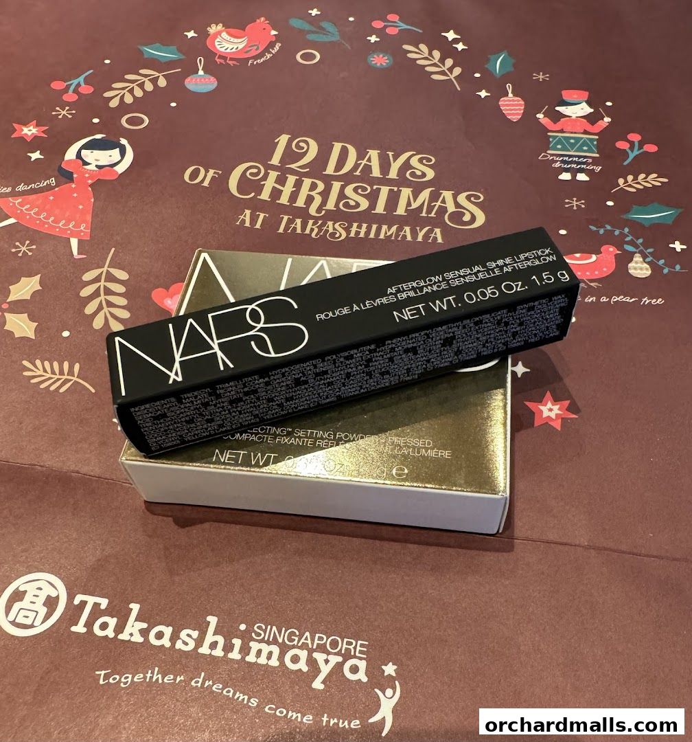 NARS lipstick and setting powder on a festive Takashimaya Christmas shopping bag.