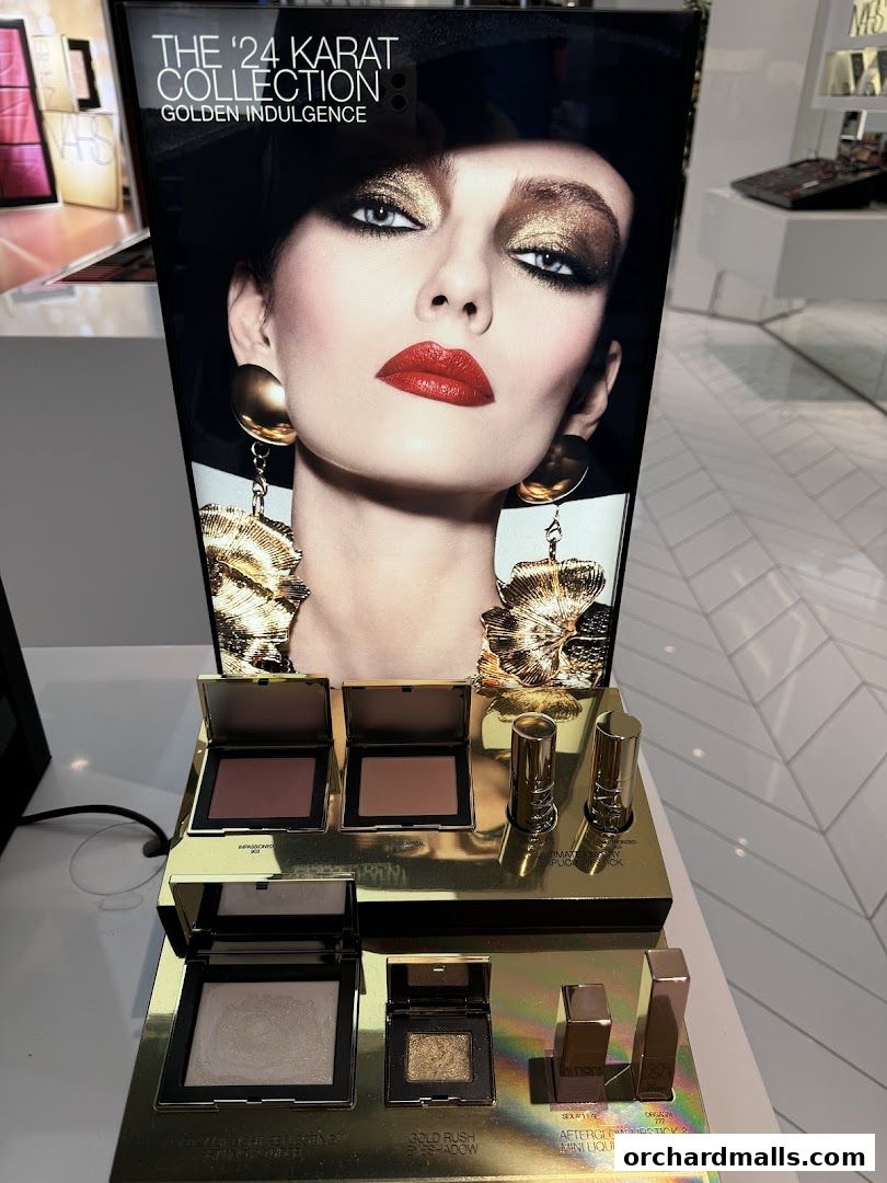 NARS '24 Karat Collection' display featuring makeup products and a model's face.