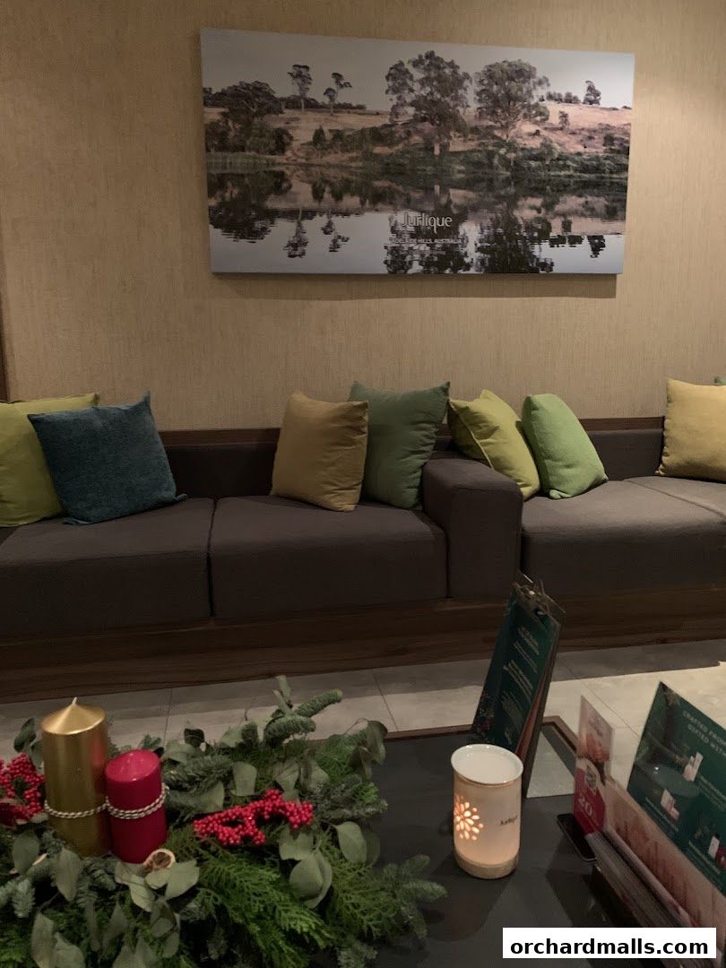 A waiting area with a sofa, cushions, and a festive centerpiece.