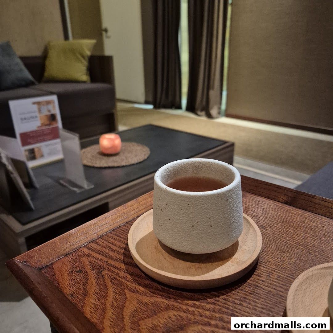A cup of tea is served on a wooden tray in a relaxing spa waiting area.