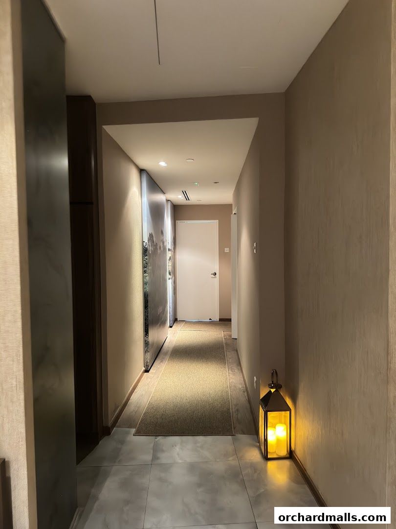 A dimly lit hallway in a spa with a lantern and artwork on the walls.
