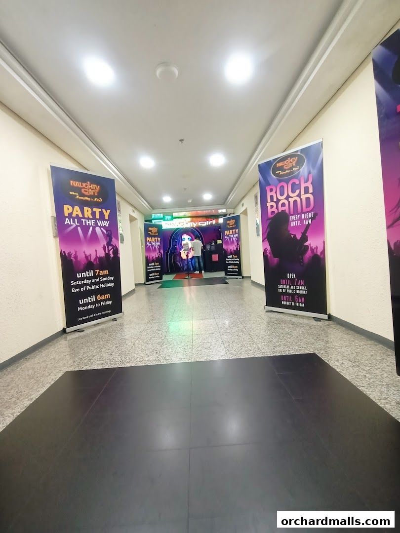 A hallway leading to the entrance of the Naughty Girl Club with promotional banners.
