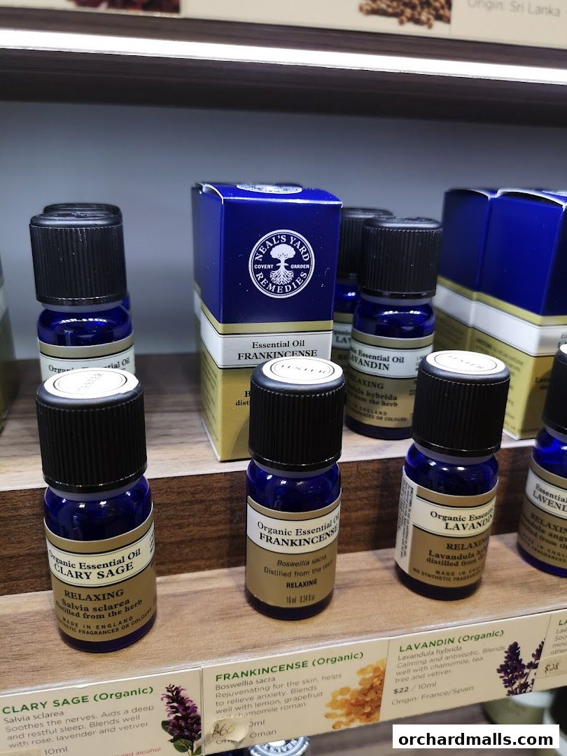 Bottles of essential oils from Neal's Yard Remedies displayed on shelves.