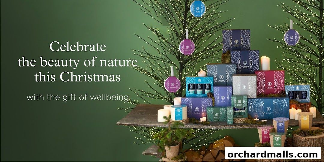 Christmas gift sets from Neals Yard Remedies displayed on shelves with festive lights.