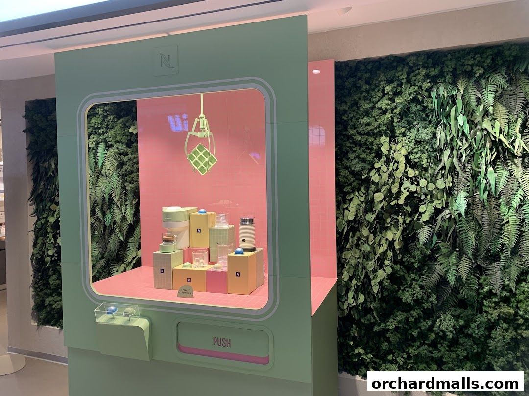 Nespresso boutique display featuring coffee machines and a claw game with greenery.