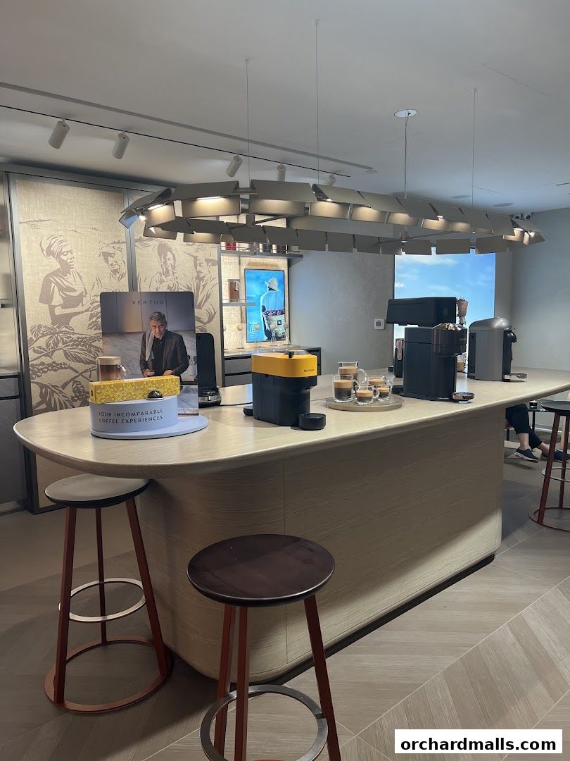 Interior of a Nespresso boutique with coffee machines and seating.