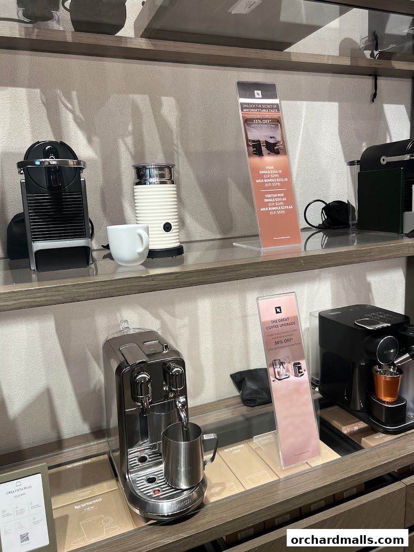 Nespresso coffee machines and accessories displayed on shelves in a retail store.