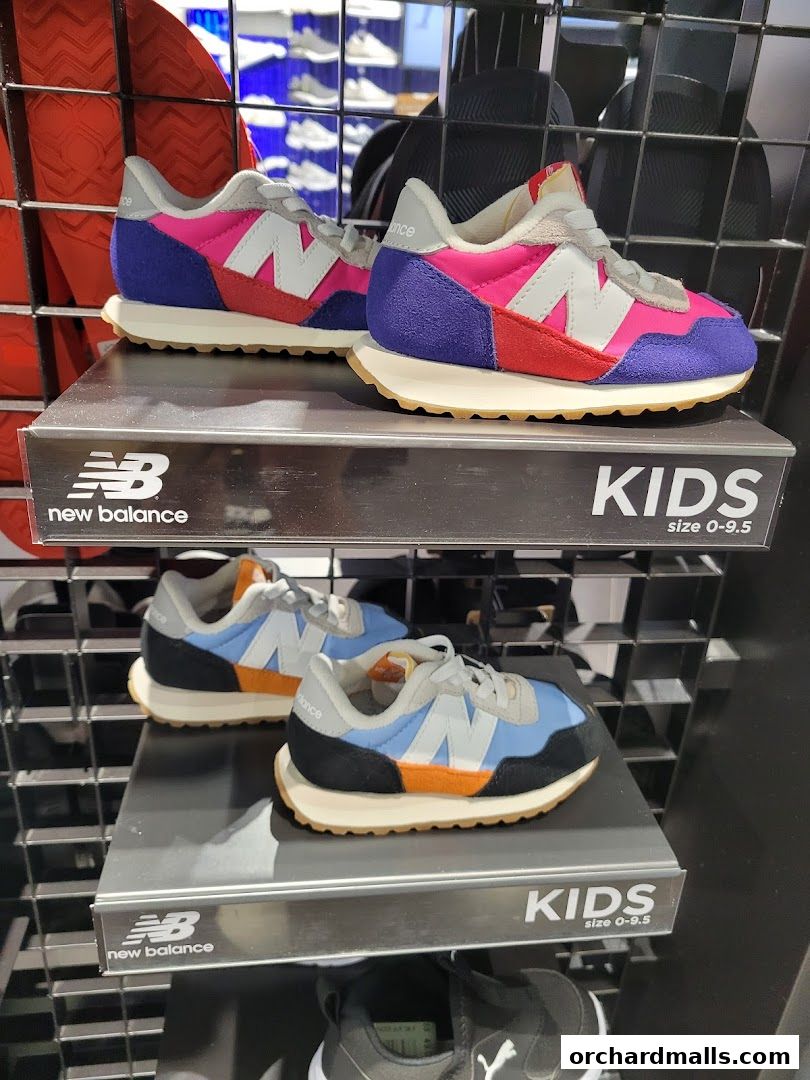 Colorful New Balance kids' sneakers displayed on shelves, showcasing various sizes and styles.