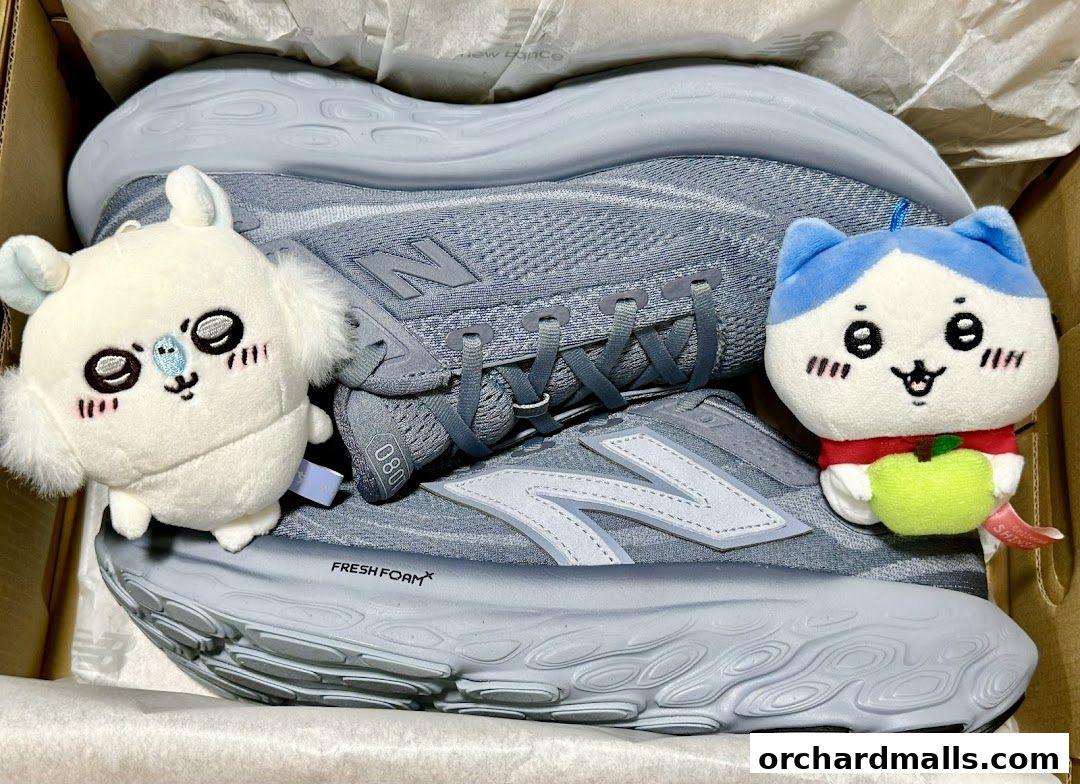 A pair of light blue New Balance sneakers with cute plush toys in a box.