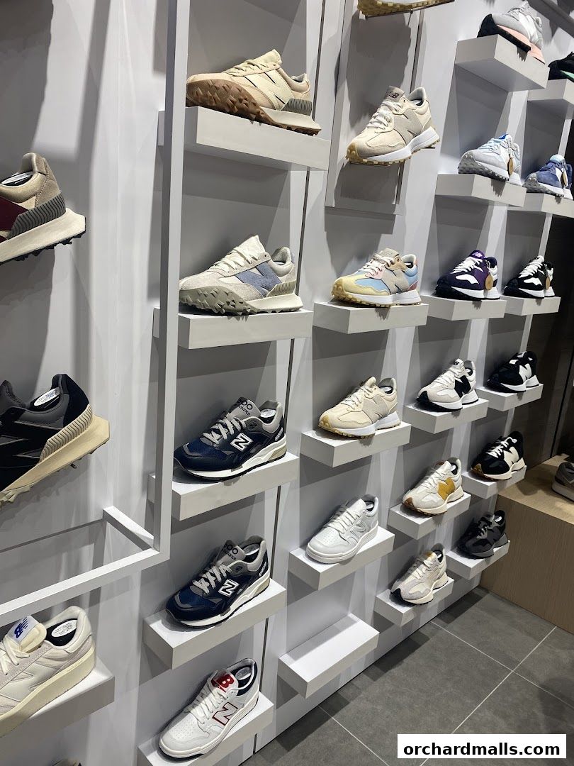A wall display showcasing a variety of New Balance sneakers in different styles and colors.