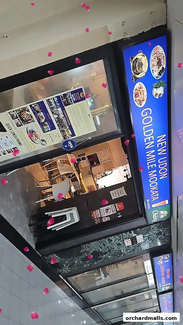 Exterior view of New Udon Mookata Thai Food restaurant with a prominent sign and menu displayed.