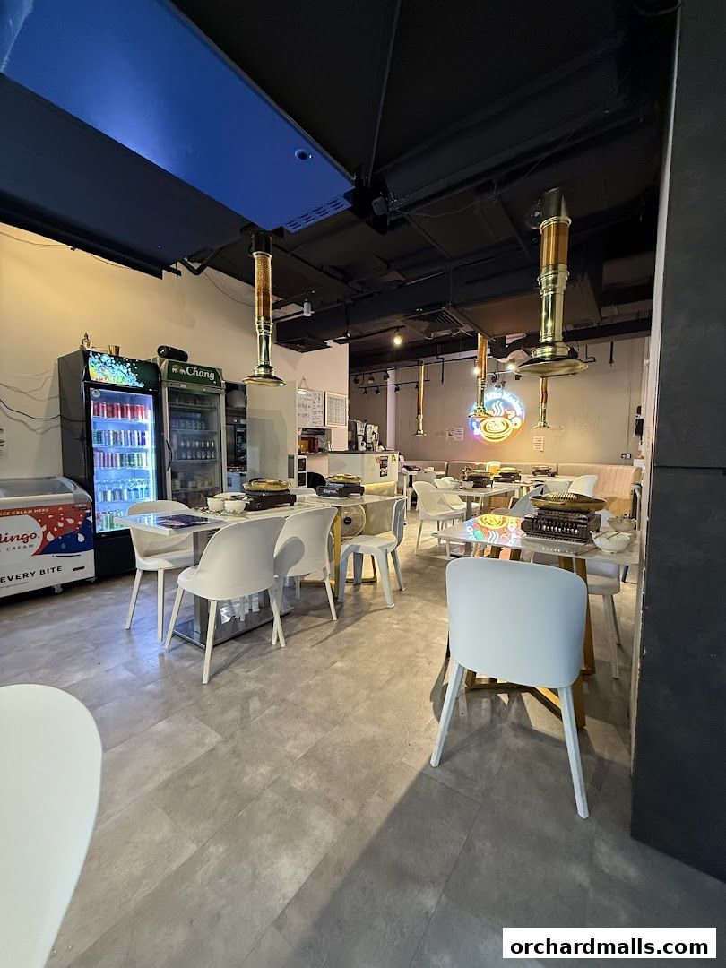Interior view of a Mookata Thai food restaurant with tables and seating.