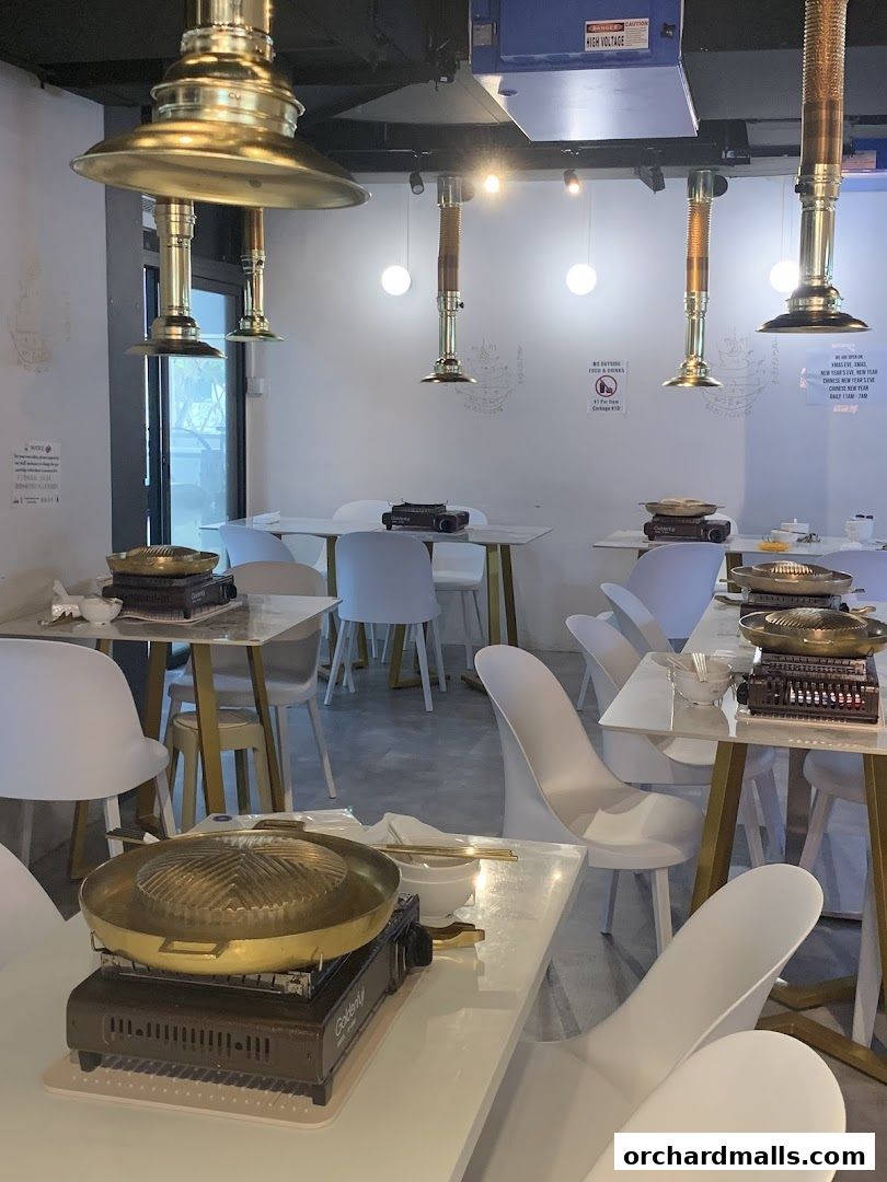 Interior of a Mookata Thai restaurant with tables set for dining.