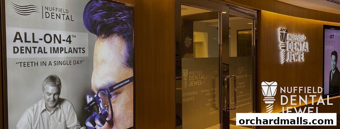 Exterior of Nuffield Dental Jewel clinic with signage and an advertisement for dental implants.
