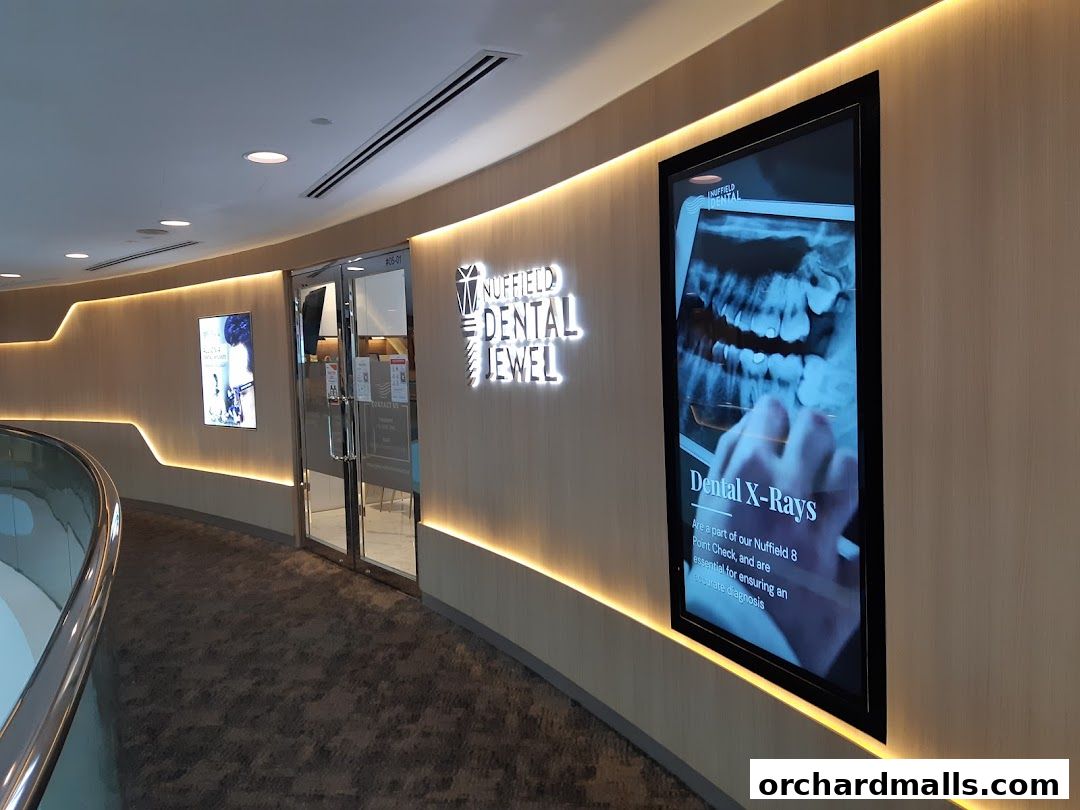 The entrance to Nuffield Dental Jewel, featuring illuminated signage and a digital display.