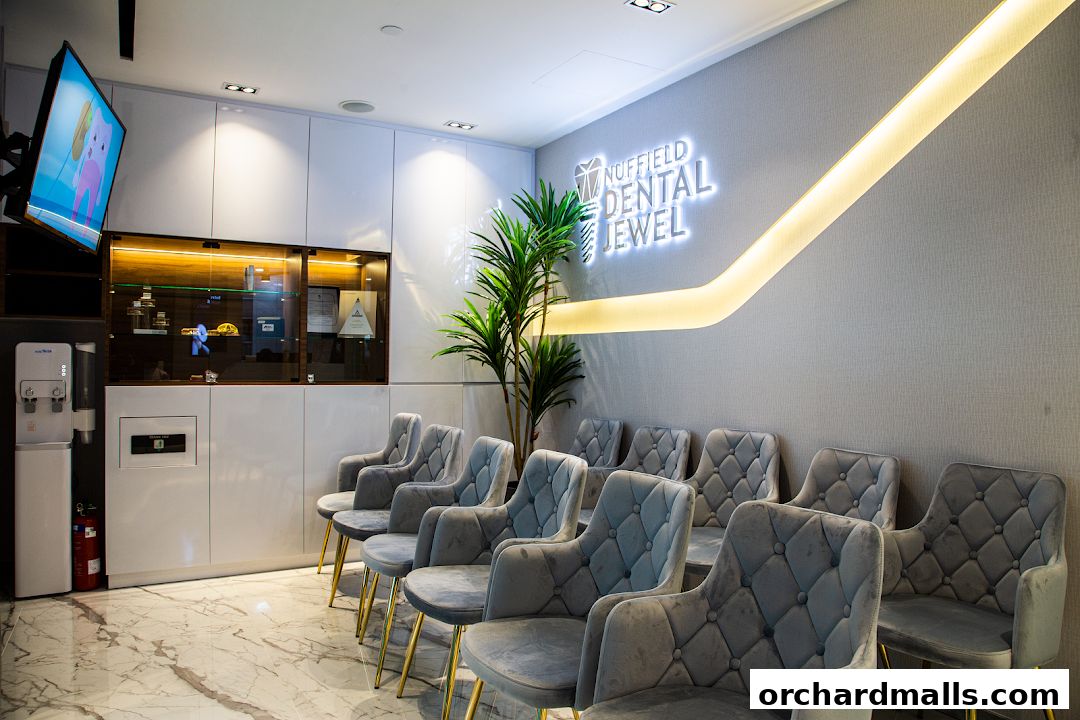 A modern dental clinic waiting area with plush chairs and a glowing sign.