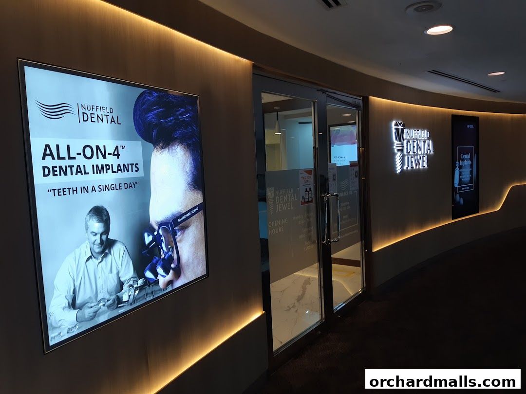 Exterior of Nuffield Dental Jewel clinic with an advertisement for All-On-4 dental implants.