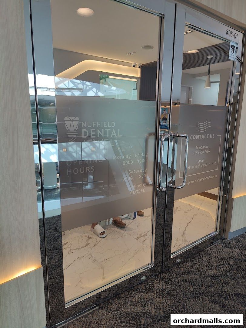 Entrance to Nuffield Dental Jewel, showing frosted glass with contact and opening hours.