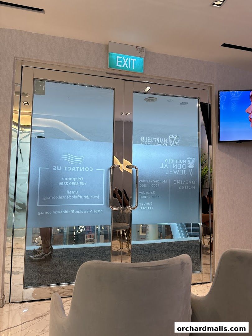 Entrance to Nuffield Dental Jewel with frosted glass doors and an exit sign.