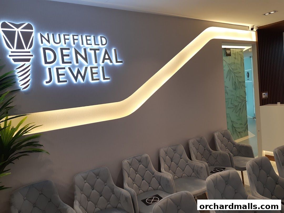Interior of Nuffield Dental Jewel showing a waiting area with plush chairs and a prominent sign.