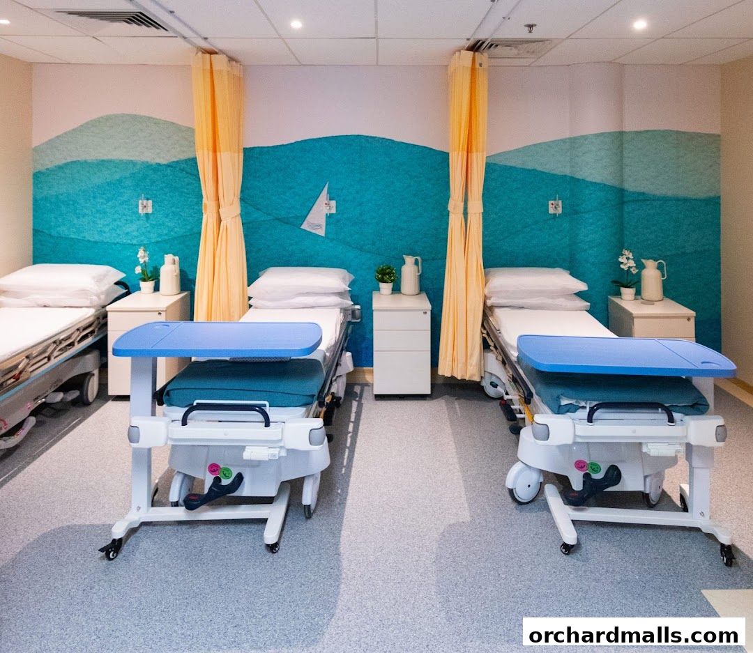 A clean and modern hospital room with three beds and a calming ocean-themed mural.