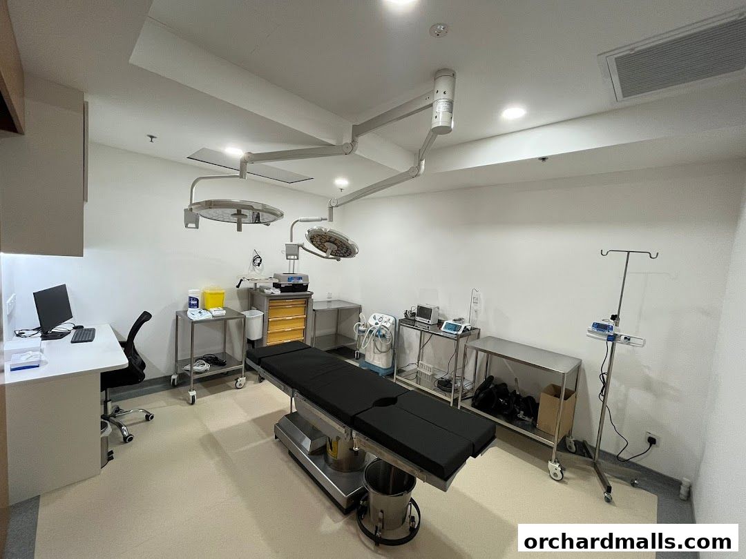 A modern medical operating room with an examination table, surgical lights, and medical equipment.
