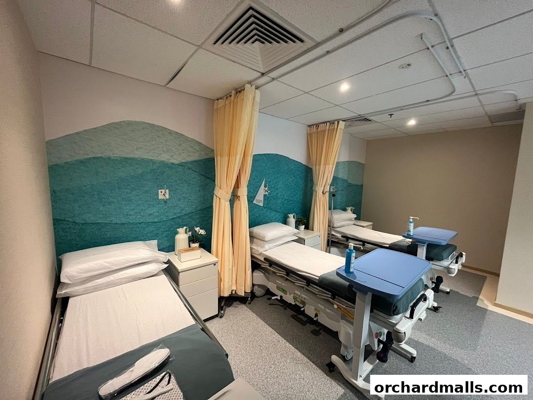 A clean medical room with three beds, bedside tables, and calming wall art.