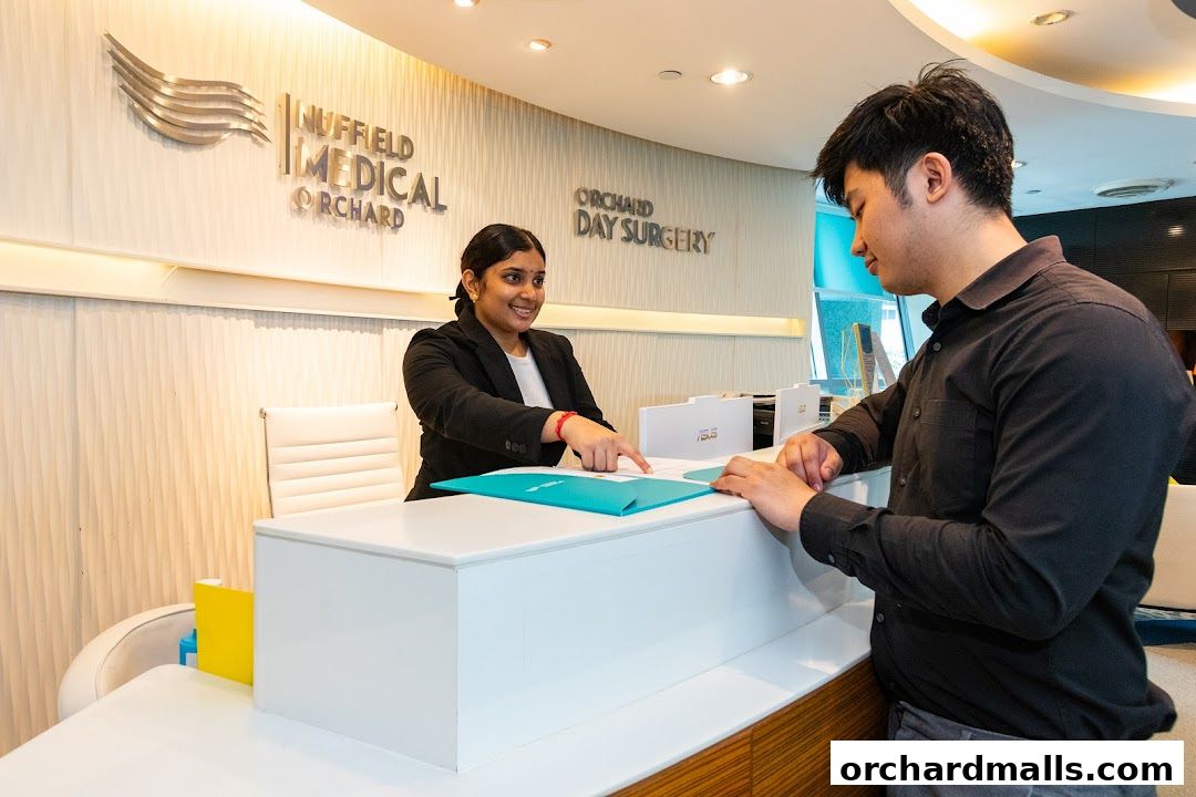 A receptionist assists a patient at the Nuffield Medical Orchard Day Surgery reception desk.