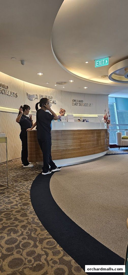 Staff at the reception desk of Nuffield Plastic Surgery, with signage visible.