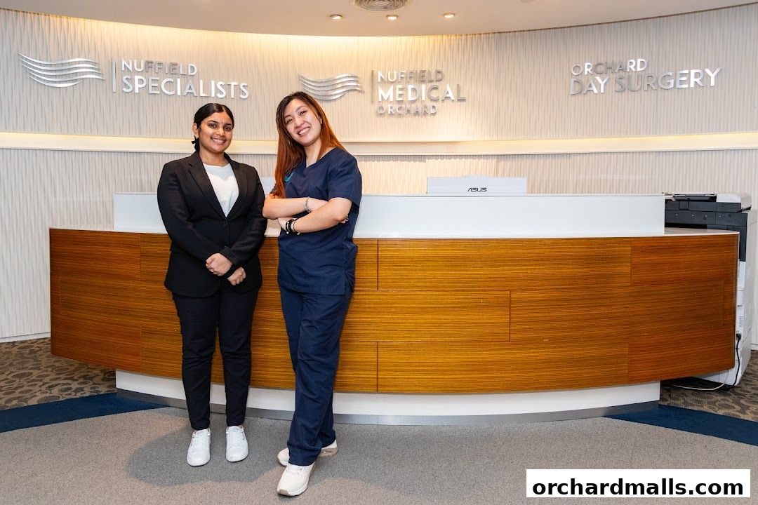 Two women stand behind a reception desk at Nuffield Medical Orchard.