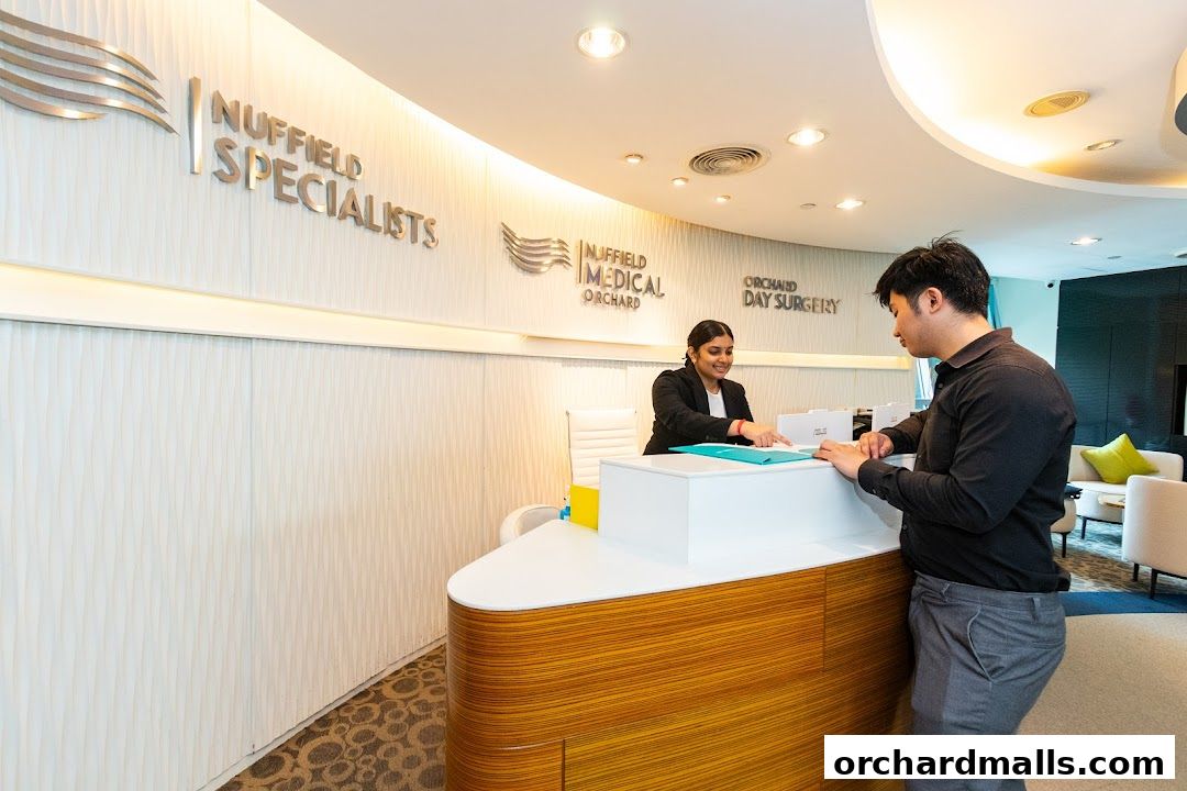 A patient interacts with a receptionist at the Nuffield Medical Orchard reception desk.