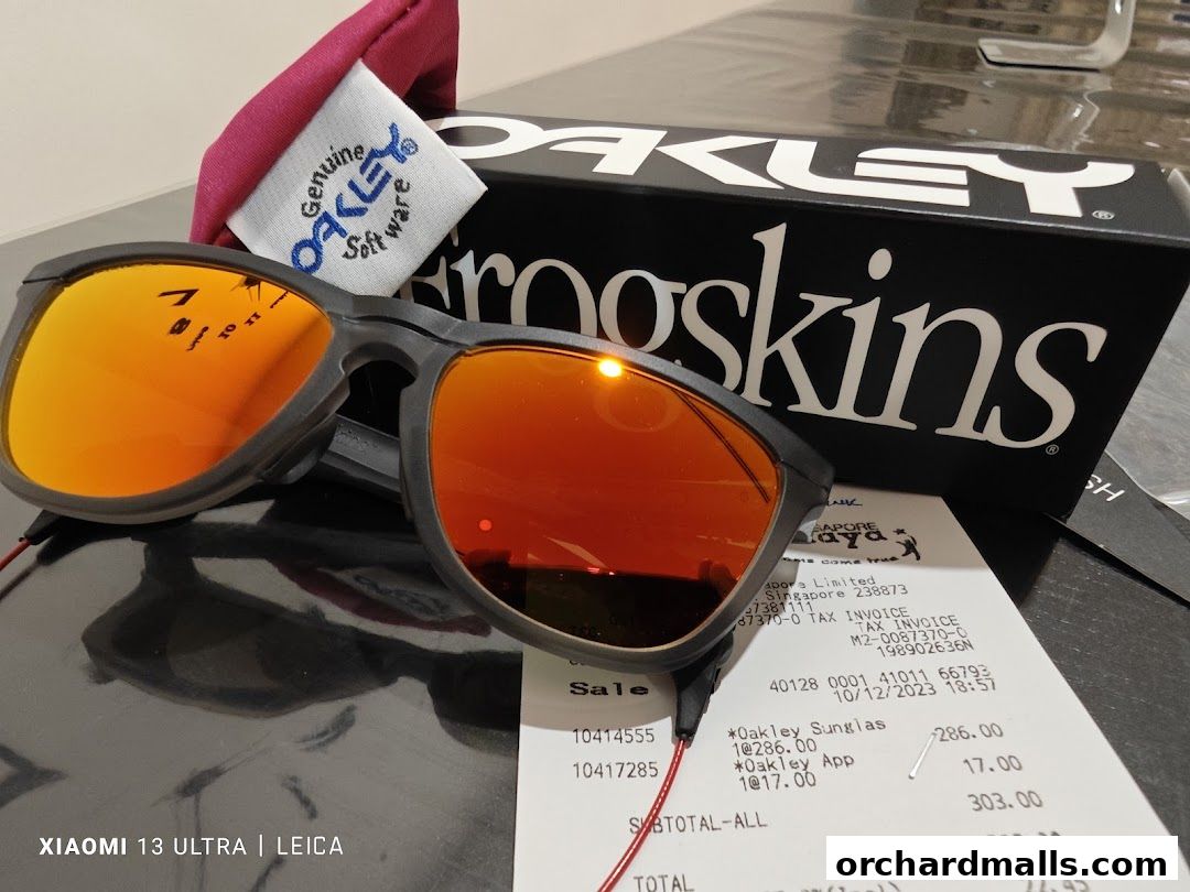 Oakley sunglasses with orange lenses and a receipt from Oakley Takashimaya.