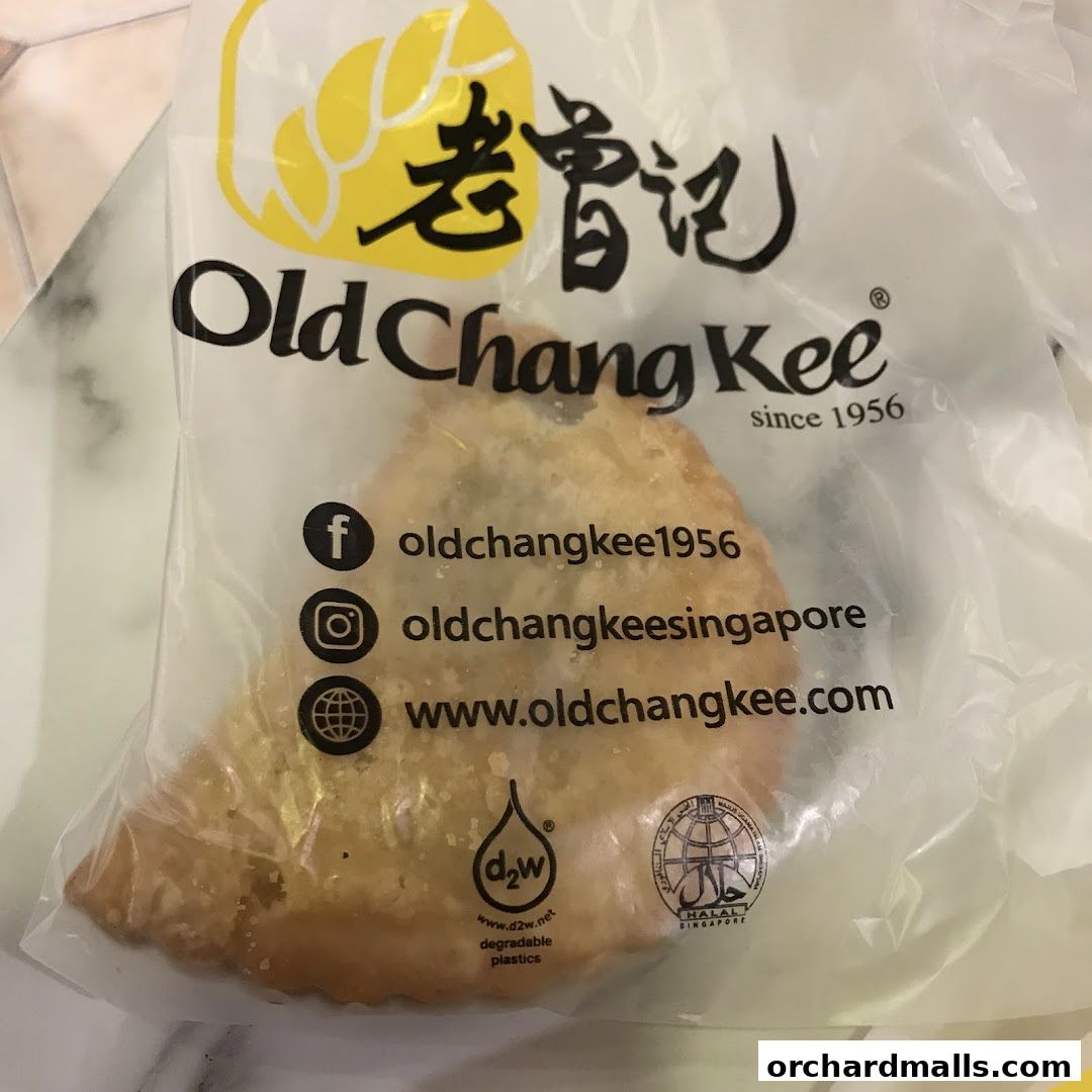 A pastry item in a clear plastic bag with the Old Chang Kee logo and social media handles.