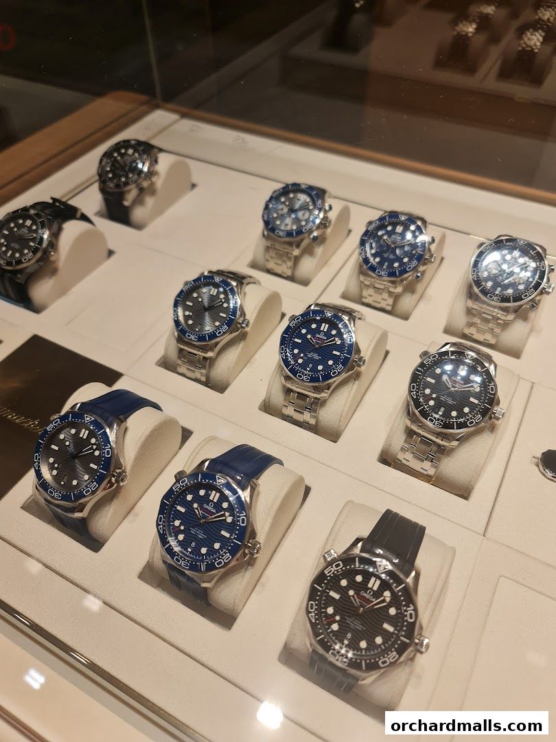 A display case showcasing various OMEGA watches with blue and black dials.