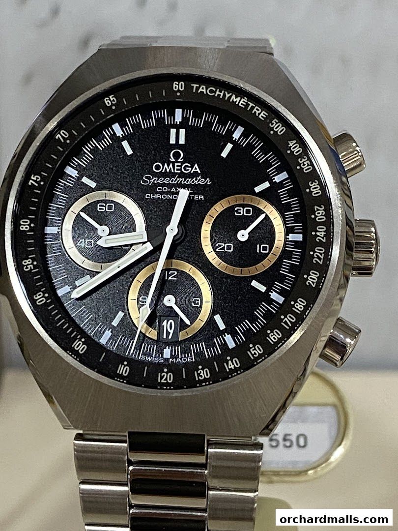 Close-up of an OMEGA Speedmaster watch with a black dial and gold accents.