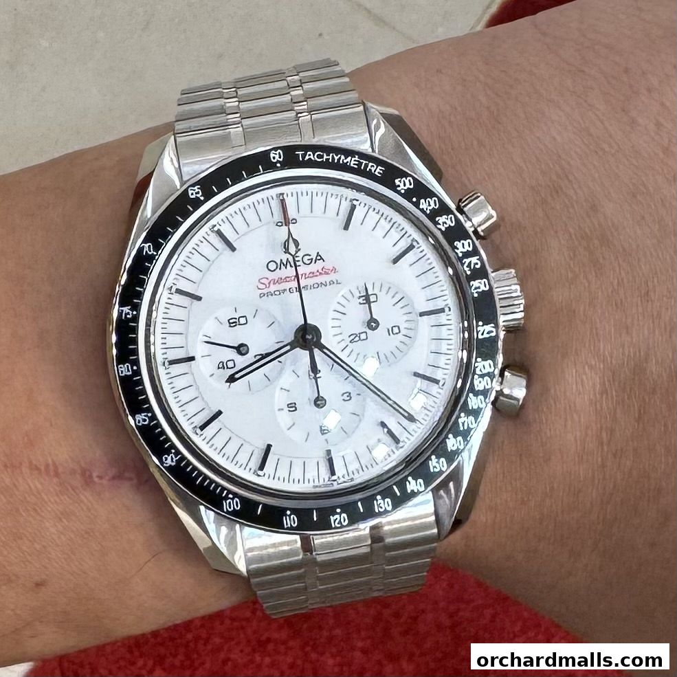 An OMEGA Speedmaster Professional watch with a white dial and tachymetre bezel on a wrist.