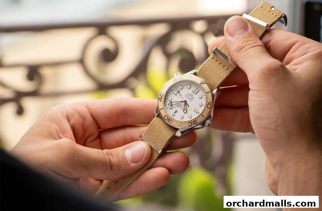 Hands holding an OMEGA Seamaster watch with a white dial and beige strap.