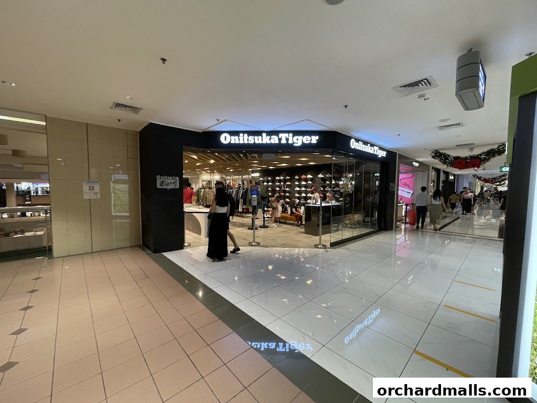 The entrance of an Onitsuka Tiger store showcasing footwear and apparel.