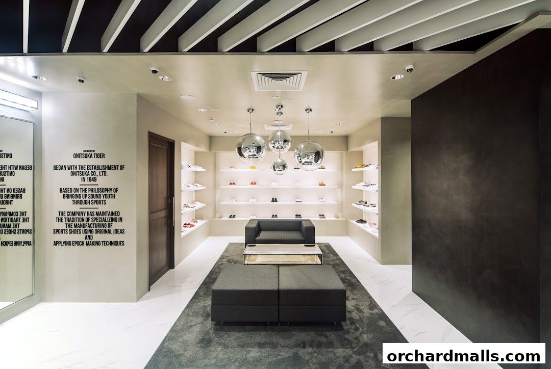 Interior of an Onitsuka Tiger shoe store with shoes displayed on shelves and a seating area.