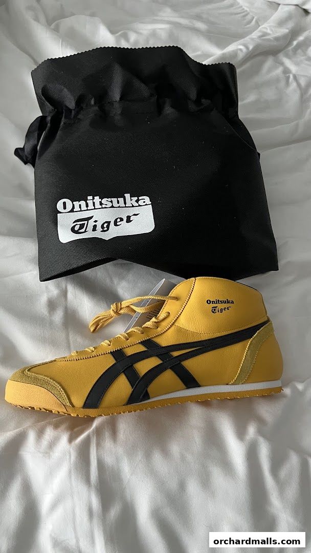 A yellow Onitsuka Tiger sneaker with a black drawstring bag.