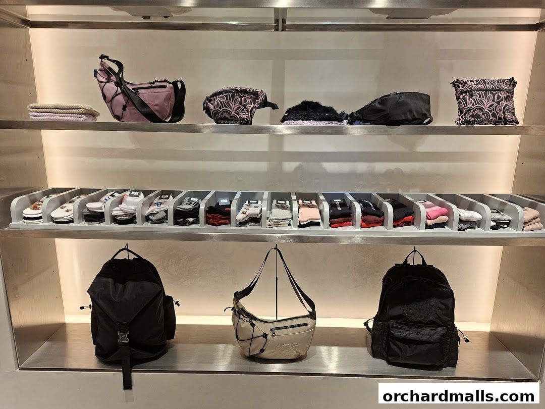 Onitsuka Tiger shop display featuring bags, socks, and backpacks on shelves.
