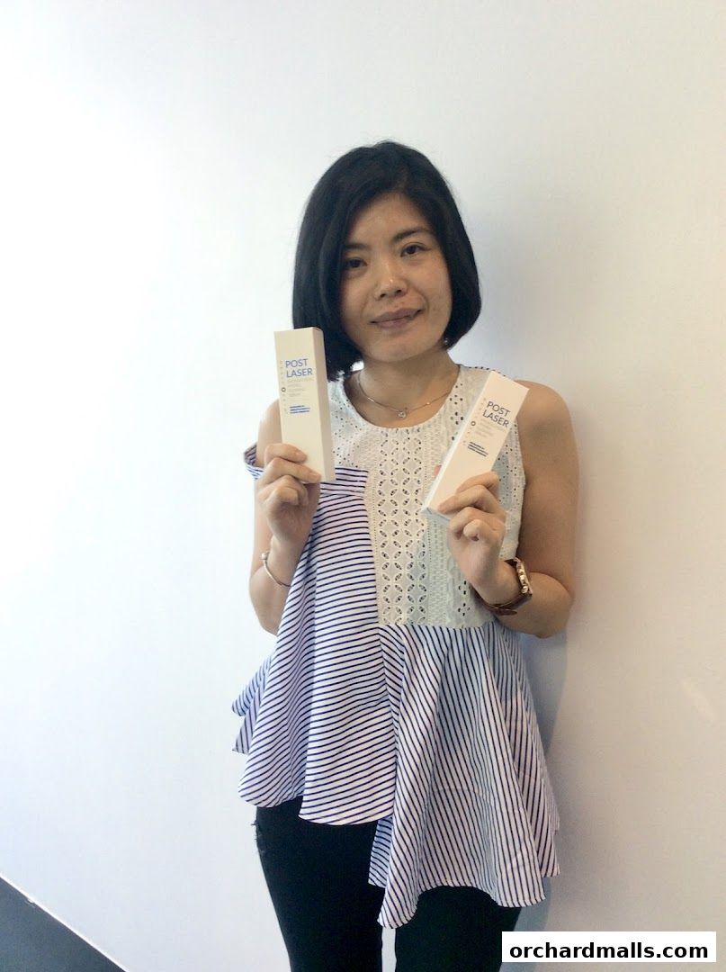 A woman holds two boxes of 'POST LASER' skincare products.