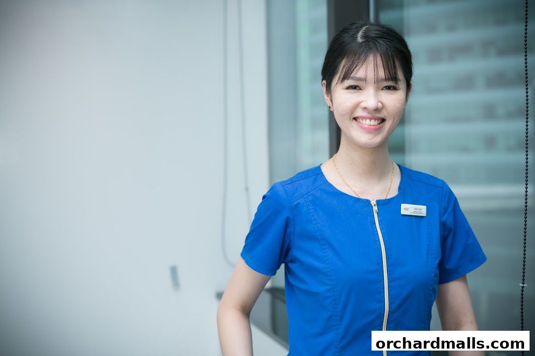 A smiling woman in a blue uniform with a name tag from Only Aesthetics.
