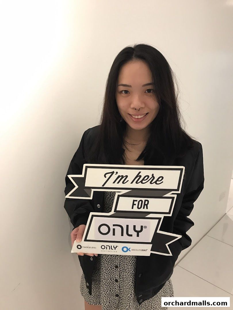 A woman holds a sign that says 'I'm here FOR ONLY' with logos below.