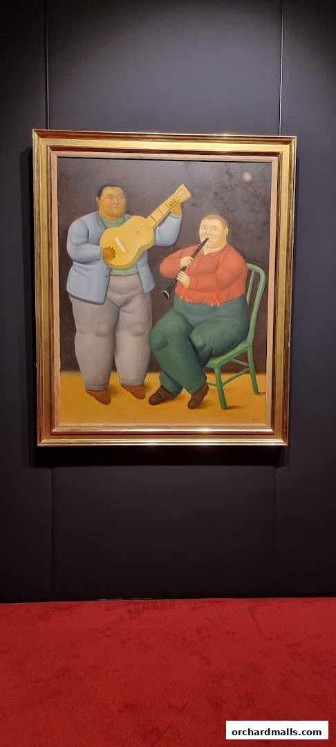 A painting of two figures playing musical instruments, displayed in a gallery setting.