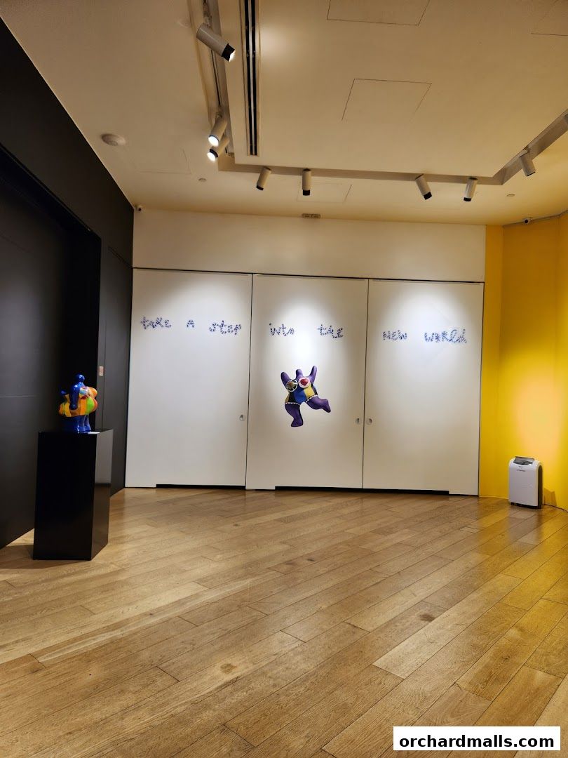 Interior of an art gallery with sculptures and text on the wall.